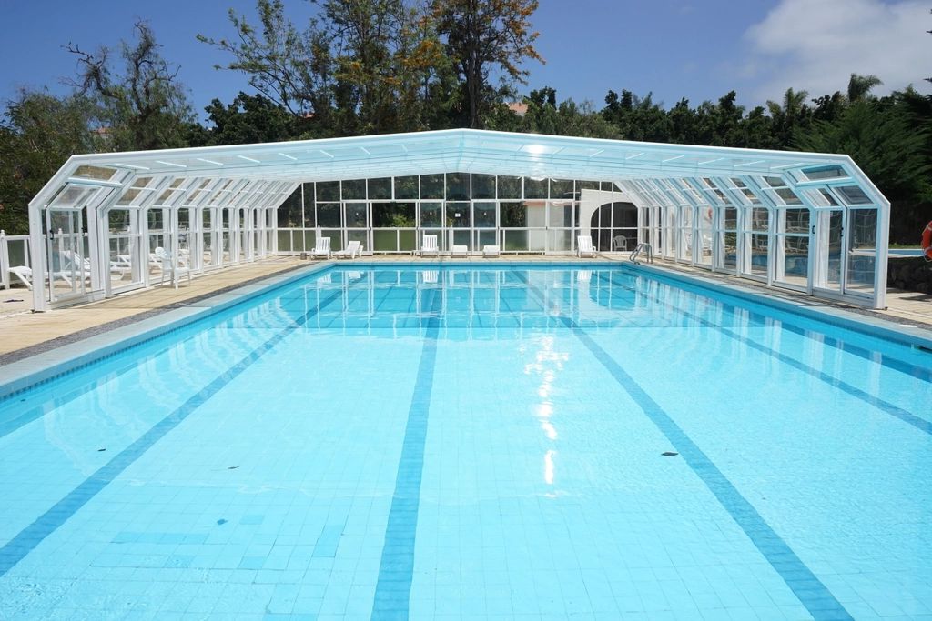 The outdoor swimming pool with loungers alongside