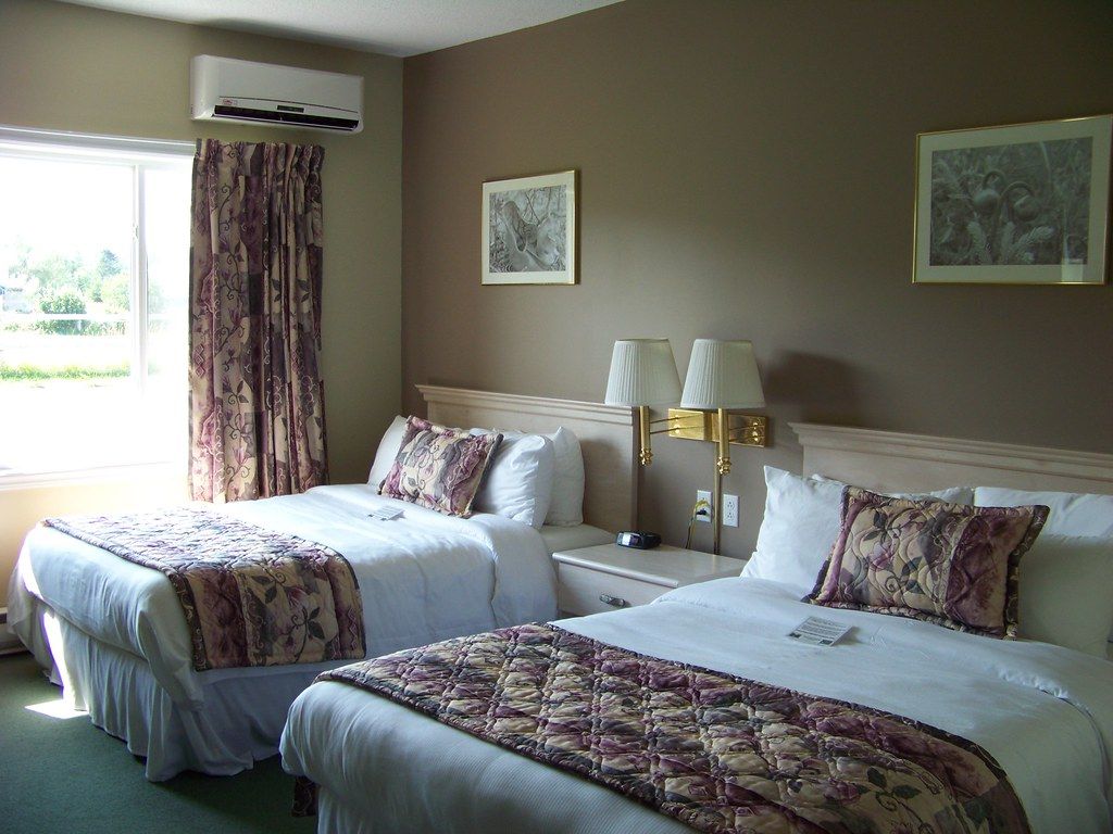 A guest room with a large bed and soft lighting